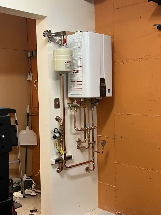 Plumbing technician inspecting water heater connections in Westwood